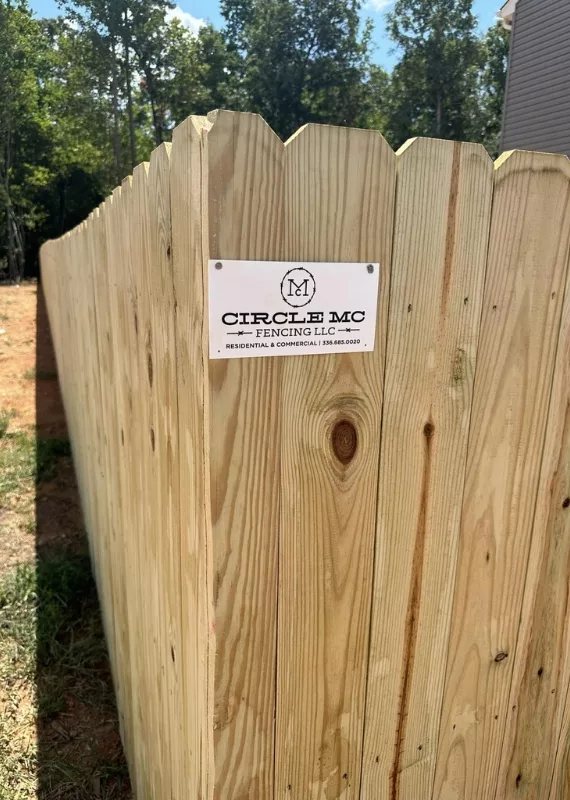 circle mc fencing logo attached to wood fence in greensboro nc